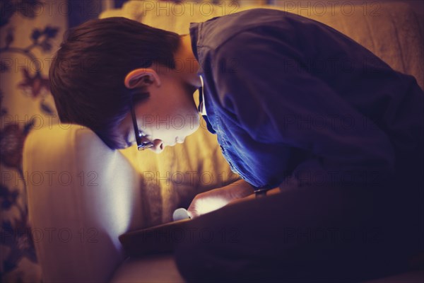 Mixed race boy using digital tablet on sofa