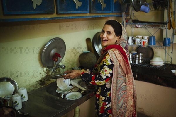 Woman washing dishes in kitchen