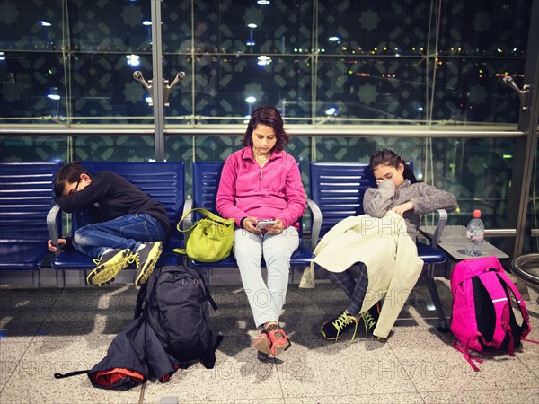 Mother and children relaxing in airport waiting area