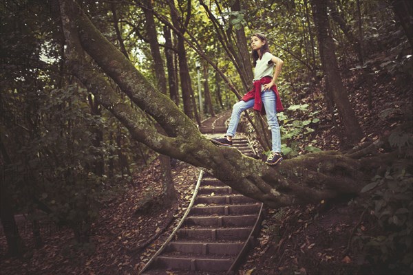 Mixed race girl exploring lush forest