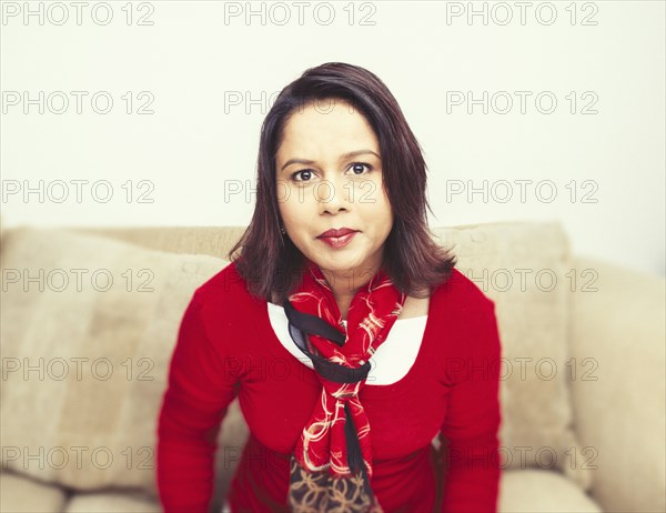 Mixed race woman sitting on sofa