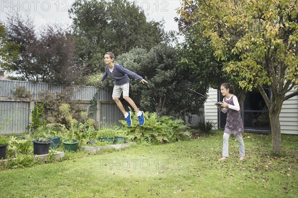 Mixed race children playing with hover toy in backyard