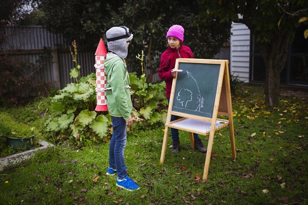 Mixed race children planning jetpack rocket