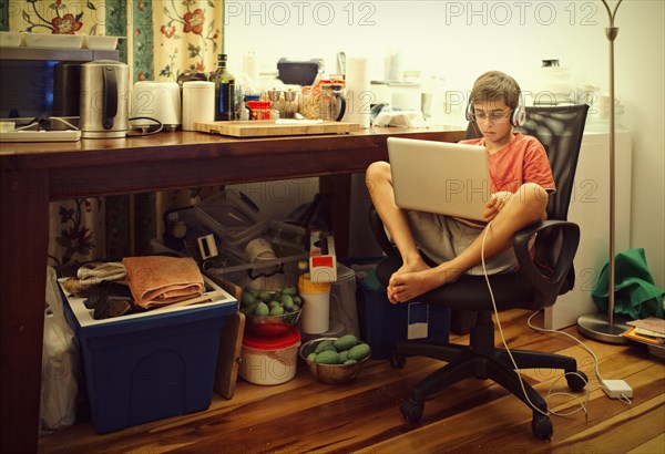 Mixed race boy using laptop in living room