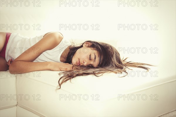 Mixed race girl sleeping on sofa