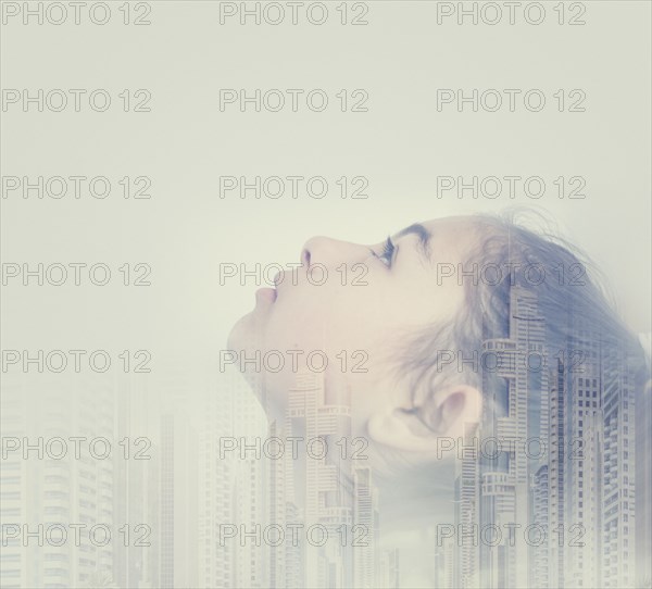 Double exposure of mixed race girl and cityscape