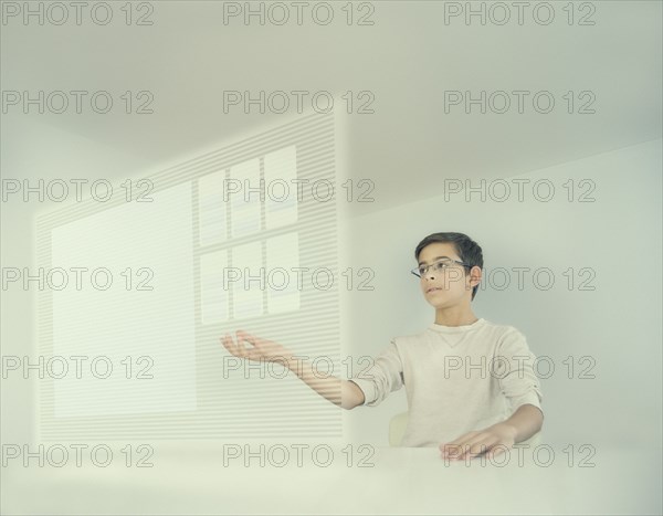 Mixed race boy using holographic screen