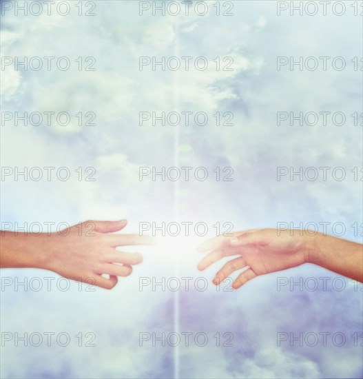Bright fingers touching in sky