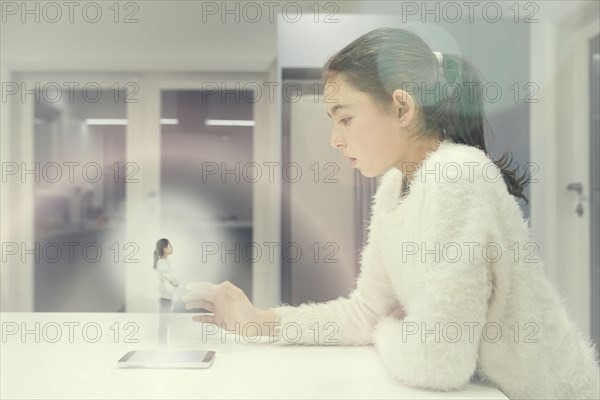 Mixed race girl examining hologram projection