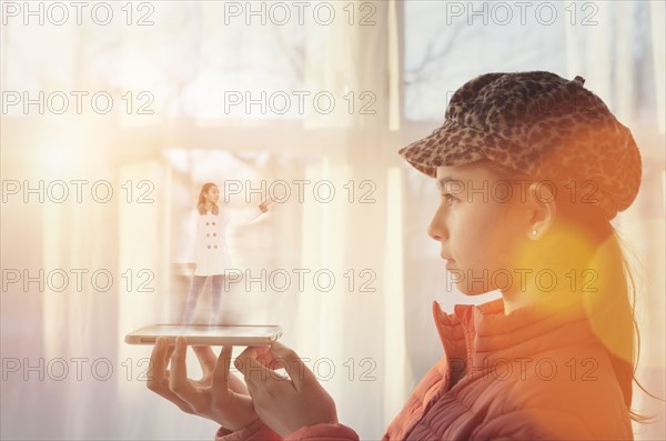 Mixed race girl examining hologram projection