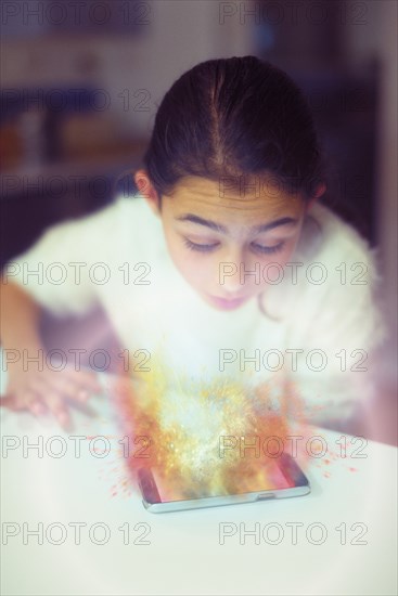 Mixed race girl examining hologram projection