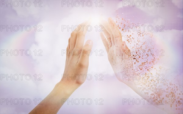 Pixelated hand of mixed race girl in sky