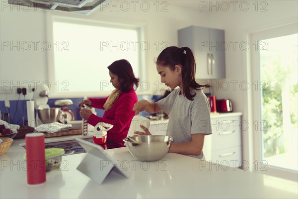 Mother and daughter cooking in kitchen