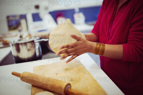 Mixed race woman cooking in kitchen
