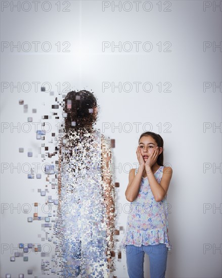 Mixed race girl with digital projection of herself