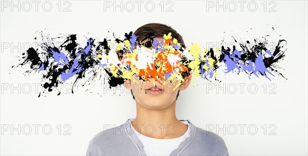 Mixed race boy with paint splatter over face