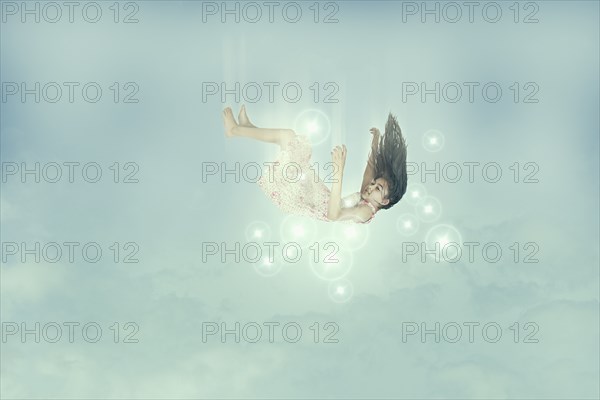 Mixed race girl falling in sky