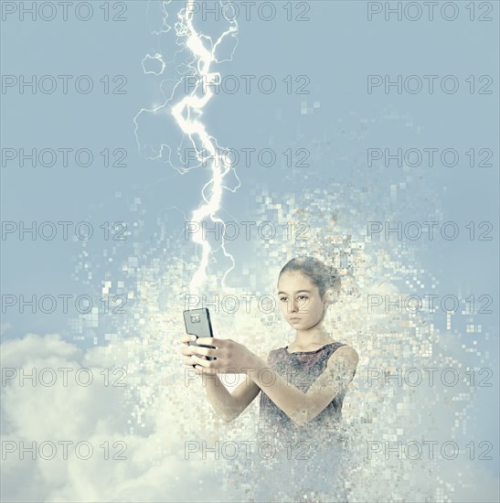 Mixed race girl holding cell phone in lightning