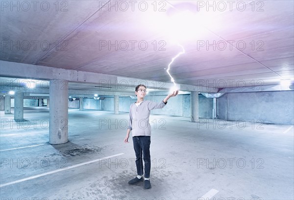 Mixed race boy holding lightning in parking lot