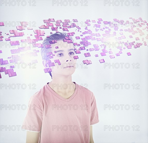 Mixed race boy looking at floating blocks