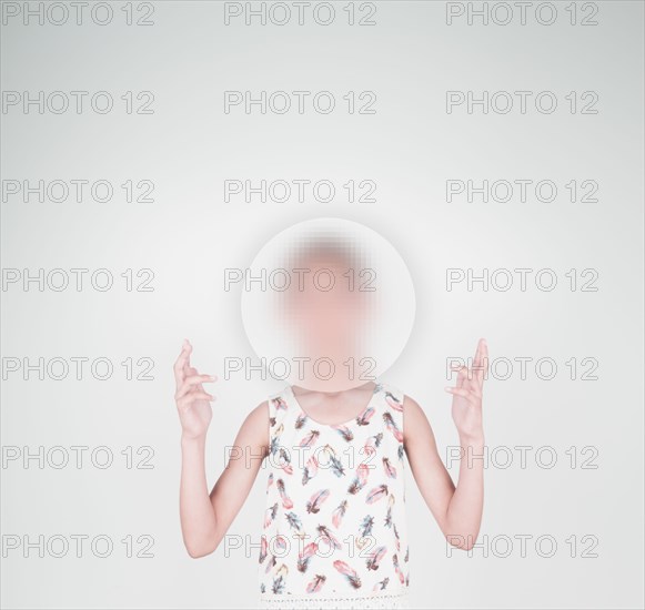 Mixed race girl with face obscured by sphere