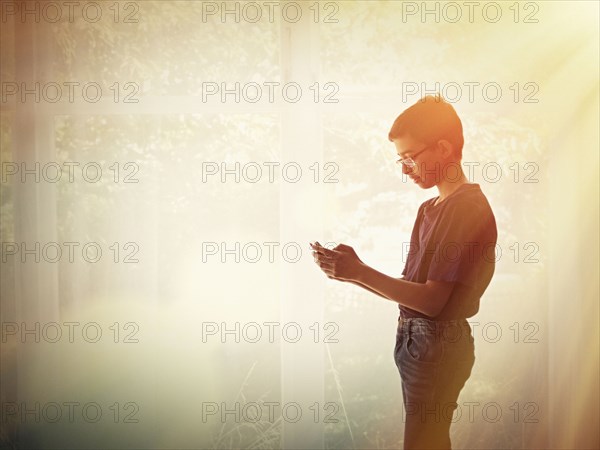 Mixed race teenage boy using cell phone