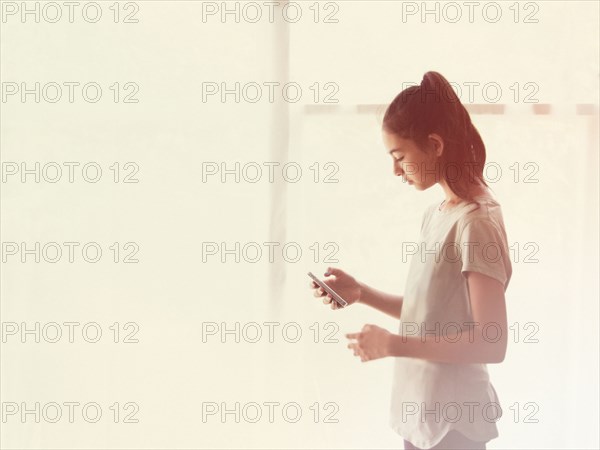 Mixed race girl using cell phone