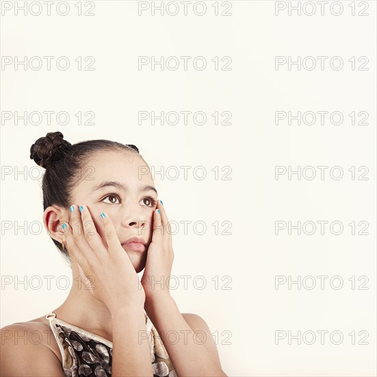 Mixed race girl holding her face