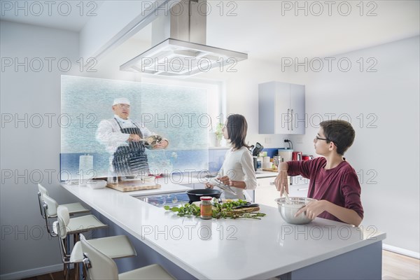 Brother and sister watching hologram cooking show in kitchen