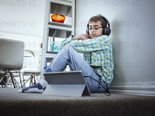 Mixed race boy using digital tablet on floor