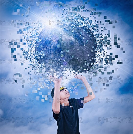 Mixed race boy watching virtual reality globe