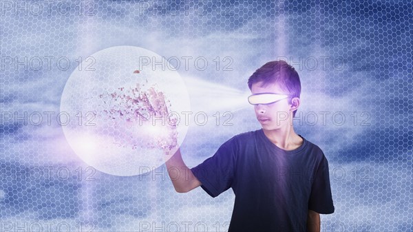 Mixed race boy watching virtual reality globe