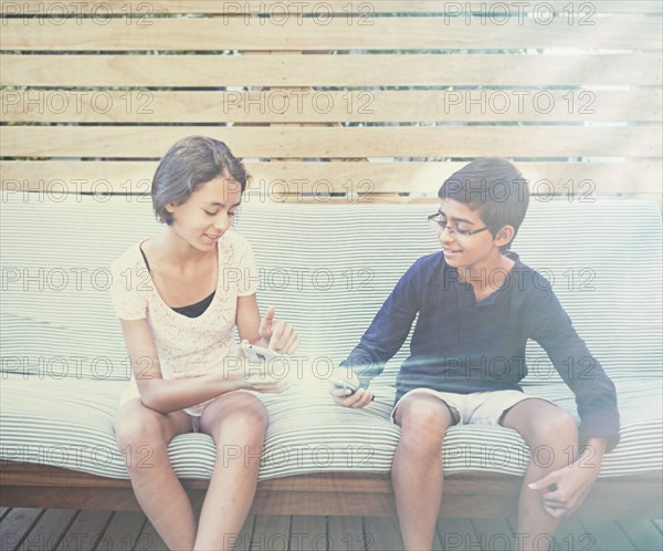 Mixed race children using glowing cell phones