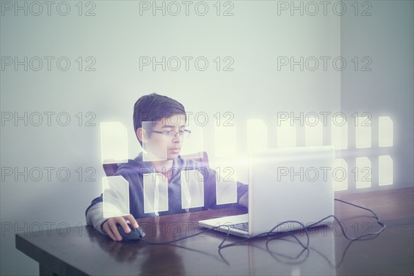 Mixed race boy using computer with holographic files