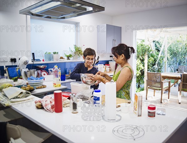 Mother and son cooking in kitchen