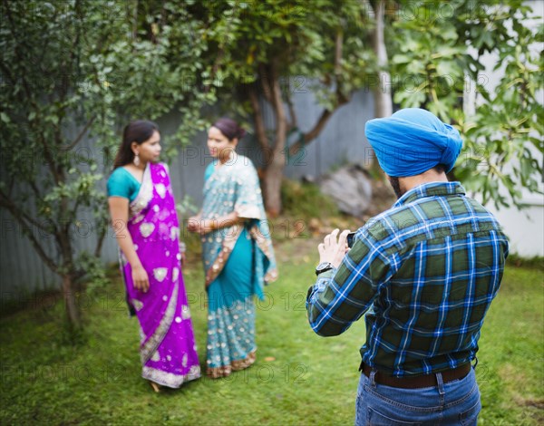 Man photographing women in traditional Indian dresses
