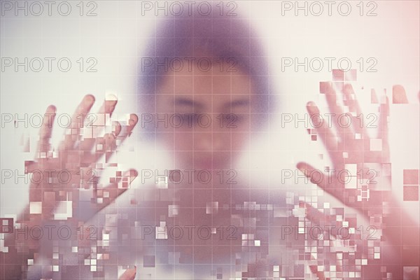 Mixed race girl standing behind pixelated screen
