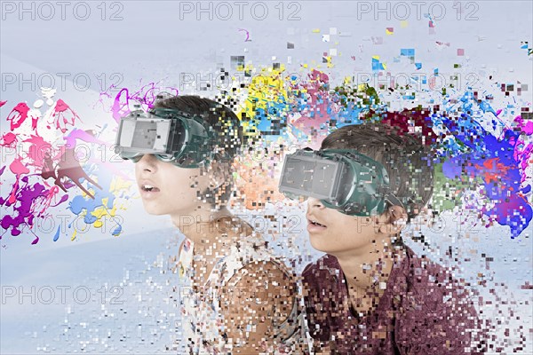 Mixed Race brother and sister watching paint splatter with VR goggles