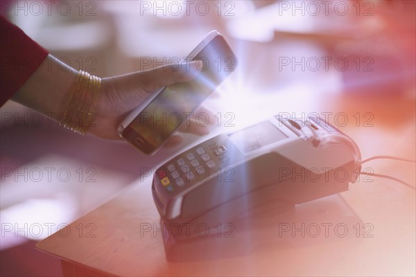 Indian woman paying with cell phone NFC technology