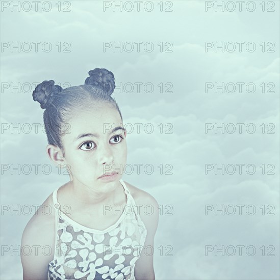 Wide-eyed Mixed Race girl in clouds