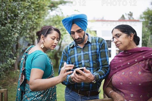 Family texting on cell phone outdoors