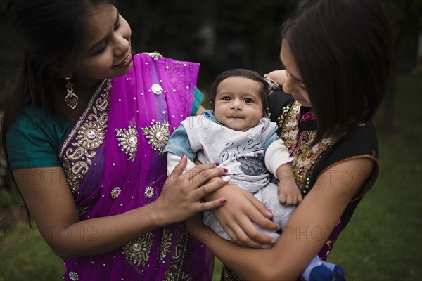 Mother and daughter admiring baby boy