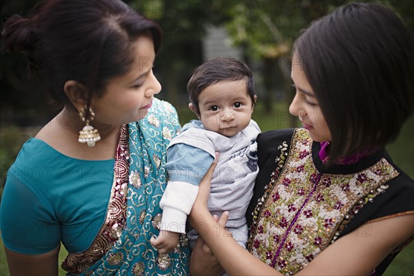 Mother and daughter admiring baby boy