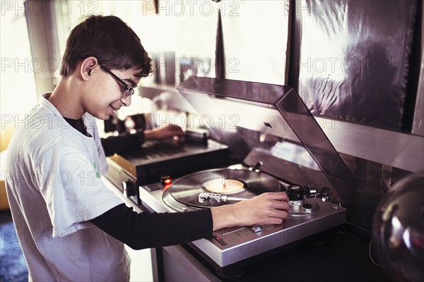 Mixed Race boy playing vinyl record on turntable