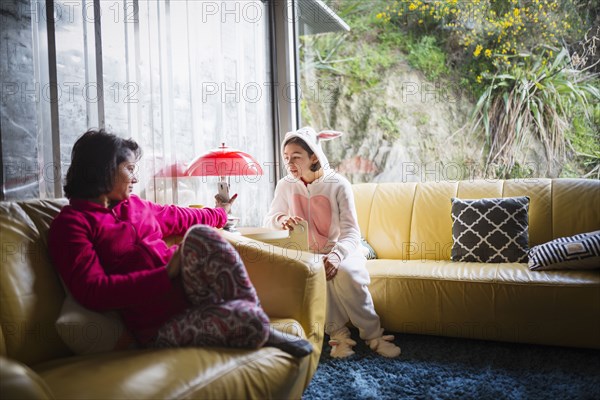 Mother showing cell phone to daughter wearing rabbit costume