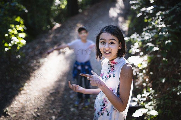 Mixed Race brother and sister on sunny path