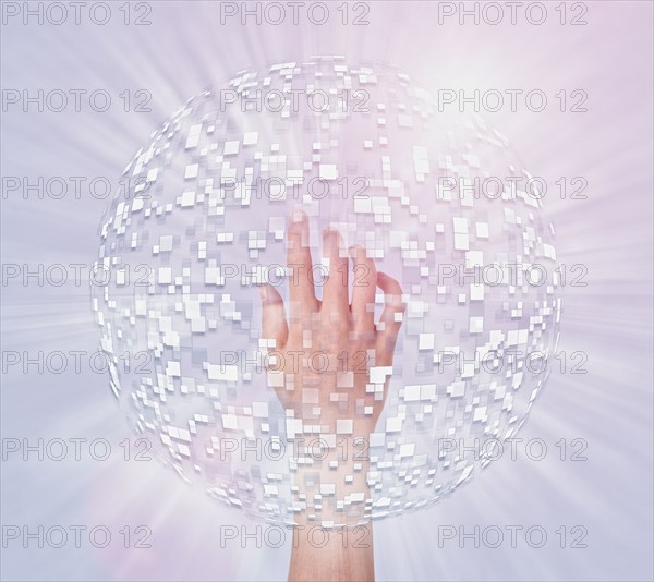 Hand of Mixed Race boy in hovering sphere of pixels