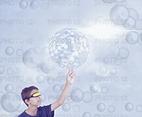 Mixed Race boy using vr goggles touching hovering pixel sphere