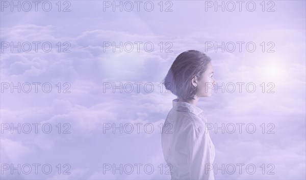 Pensive Mixed Race girl in clouds