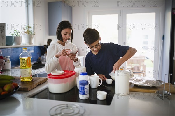 Mixed Race brother and sister baking in kitchen